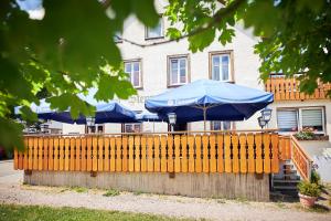 FriedenweilerGasthof & Pension Steppacher的建筑前带蓝色伞的栅栏
