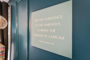 埃文河畔斯特拉特福Emerald Stays UK at The Adelphi的蓝墙上画的画架,上面有引号