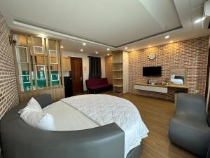 头顿The Land Hotel & Apartment的卧室配有白色的床和电视。