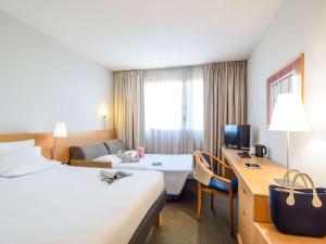 都灵诺富特都灵诺科尔索朱利奥塞萨尔酒店的酒店客房配有两张床和一张书桌