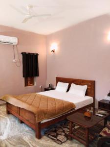 RājgarhSadhna Sadan stay mountain and river view Panna tiger reserve的一间卧室配有一张大床和一张桌子