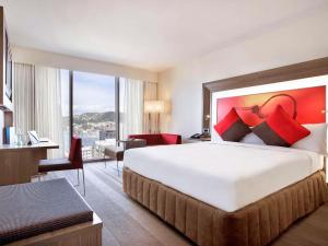 惠灵顿惠灵顿诺富特酒店的一间酒店客房,设有一张大床和一个大窗户