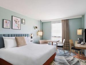 亚眠亚眠教堂美居酒店的酒店客房设有一张大床和一张书桌。