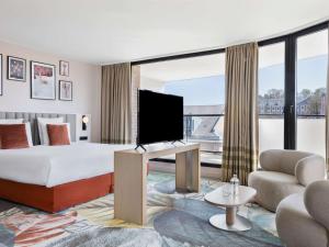 亚眠亚眠教堂美居酒店的配有一张床和一台平面电视的酒店客房