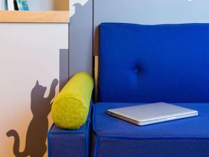 蒙彼利埃Aparthotel Adagio access Montpellier Centre的蓝椅,带笔记本电脑和枕头