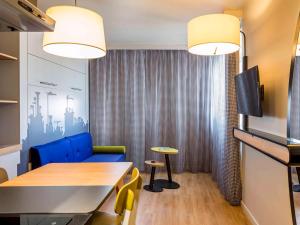 蒙彼利埃Aparthotel Adagio access Montpellier Centre的一间小餐厅,配有桌子和蓝椅