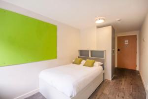 爱丁堡比佛班克广场 - 校园公寓的卧室配有白色床,墙上挂有绿色画作