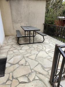 珀套特科姆博特Hôtel Les 4 Chênes的石质天井上的野餐桌和长凳