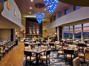 里士满温哥华机场航站楼费尔蒙酒店的一间设有桌椅的餐厅,位于带窗户的房间内