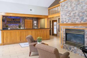 锡达拉皮兹AmericInn by Wyndham Cedar Rapids North的客厅设有壁炉和椅子