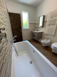 阿拉西奥Holiday Rooms La Campagnetta的带浴缸、卫生间和盥洗盆的浴室