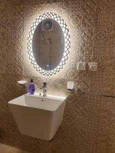 麦地那شقة جمان طيبة Joman Taibah Apartment的浴室设有白色水槽和镜子