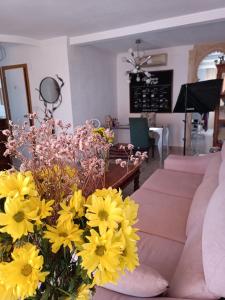 贝纳尔马德纳Coty's Beach的客厅配有黄色的鲜花和沙发