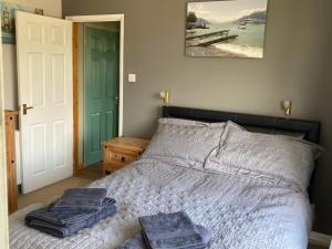 伍尔Ballantrae的一间卧室配有一张床,上面有两条毛巾