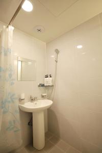 庆州Stay RomanticTrip_Hostel的白色的浴室设有水槽和镜子