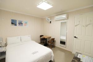 庆州Stay RomanticTrip_Hostel的卧室配有白色的床、桌子和门