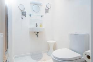 卡迪根The Garden Room Apartment的白色的浴室设有卫生间和水槽。