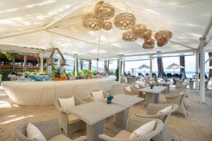 卡马拉海滩InterContinental Phuket Resort, an IHG Hotel的一间带桌椅的餐厅和一间酒吧