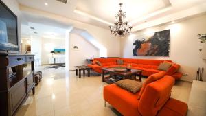 DhafnésLuxury Villa Allure的客厅配有橙色沙发和桌子