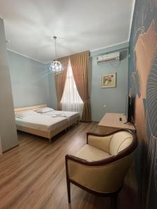 塔拉兹Гостиница Amulet的一间卧室配有一张床、一把椅子和一张沙发
