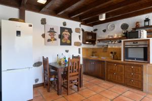 蒂亚斯Casa Amaia II的厨房配有桌子、电视和冰箱。