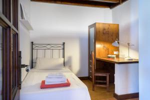 蒂亚斯Casa Amaia II的一间卧室配有一张带书桌和一张桌子的床。