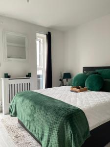 曼彻斯特Cosy Bedrooms的一间卧室配有一张带绿色枕头的大床