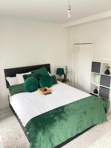 曼彻斯特Cosy Bedrooms的白色卧室配有一张带绿色枕头的大床