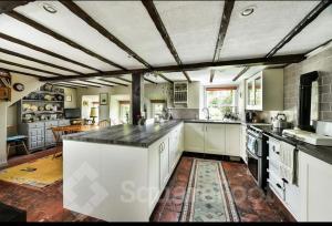 斯特灵Powis House East Cottage的一个带白色橱柜和大岛的大厨房