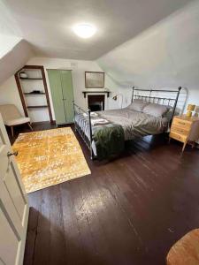斯特灵Powis House East Cottage的一间卧室配有一张床,铺有木地板