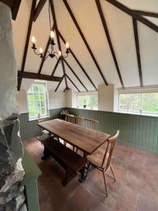 斯特灵Powis House East Cottage的一间带木桌和椅子的用餐室