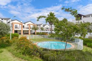 佛维斯V&S Apartments - Executive Suite in Fourways, Johannesburg的游泳池周围的围栏,有房子的院子