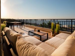 赫索尼索斯Zuzu Riviera Living的客厅配有沙发和阳台桌子