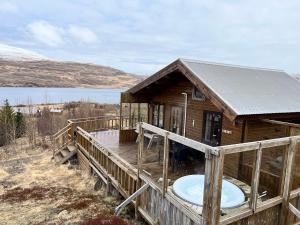 阿克拉内斯Icelandic Lake House的大型木制房屋的甲板上设有浴缸