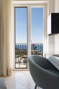 卡普里普罗拉酒店的客厅配有椅子,享有海景