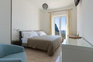 卡普里普罗拉酒店的白色的卧室设有床和窗户