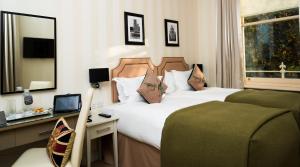 伦敦森雅酒店 - 签名收藏的酒店客房设有两张床、一张桌子和一面镜子