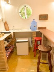 因巴塞Chalé Nova Terra的厨房配有水槽和带两个凳子的台面
