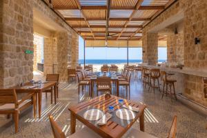 马萨阿拉姆Wadi Sabarah Lodge的一间带桌椅的海景餐厅