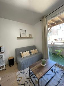 泰尔地区罗谢福尔Studio - 19的一间卧室配有一张床、一张桌子和一个窗户。