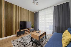 弗罗茨瓦夫Apartment with 2 Bedrooms & Parking Wrocław by Renters的客厅配有电视和蓝色沙发。