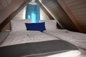 拉斯特Chalet im See- Nr 44的阁楼上一张带蓝色窗帘的床