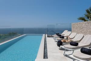 吉亚德伊索拉KARAT Villa Zambrano - INCLUDES GOLF CART and DAILY MAID SERVICE的游泳池旁的一排躺椅