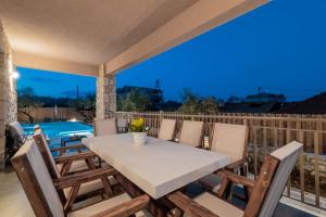 瓦西里科斯Claudio Stone House的享有泳池景致的甲板上的桌椅