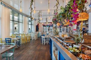 特拉维夫West Tel Aviv- All Suites Hotel By The Sea的一间带桌椅和食品柜台的餐厅