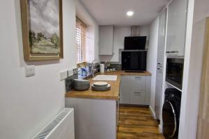 埃尔特姆1 Bedroom Studio的厨房配有白色橱柜和台面