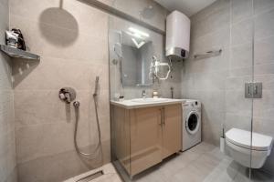 布德瓦City Apartments 2的带淋浴、盥洗盆和洗衣机的浴室