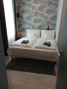 埃格尔Cherry II Apartman的一张带两个枕头和墙壁的白色床