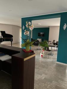 泰卡斯Hotel il Rosone的一间带钢琴的客厅和一间带钢琴的客厅