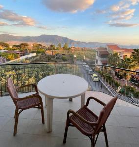 泰卡斯Hotel il Rosone的阳台上配有一张白色的桌子和两把椅子